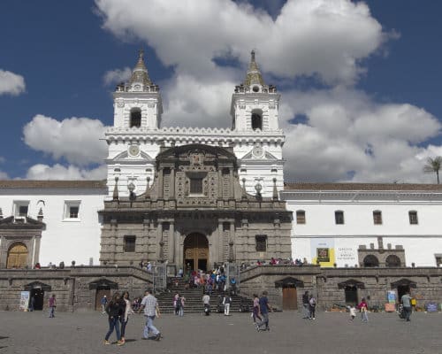 A colonial church with a gray front of volcanic stone contrasting with its stark white walls and towers